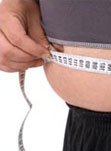 man measuring his tummy with tape measure