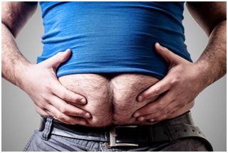 Man squeezing his pot belly with two hands